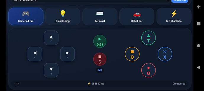 A digital interface screen showing control buttons for a GamePad Pro app, including directional arrows, play/pause, coloured action buttons, and navigation options at the top for Smart Lamp, Terminal, Robot Car, and IoT Shortcuts. (Captioned by AI)