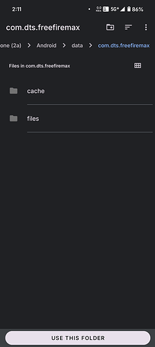 A file manager interface on a mobile device showing the folder path 'com.dts.foerefreemax' with two subfolders named '.cache' and 'files', and a button labelled 'USE THIS FOLDER' at the bottom. (Captioned by AI)
