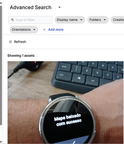 A person is wearing a smartwatch displaying the message 'Mapa baixado com sucesso' in Portuguese, with a keyboard visible in the background. (Captioned by AI)