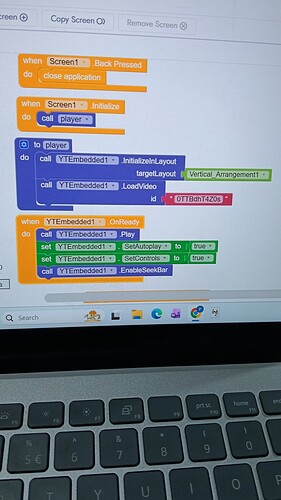 A close-up photo of a computer screen shows a visual programming interface with colored blocks arranged to control a sprite's movement and detect keyboard inputs. (Captioned by AI)